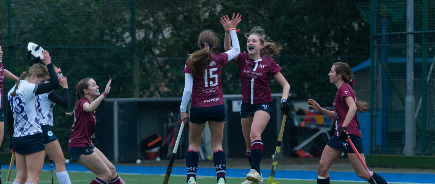 Senior Girls' Hockey team celebrating scoring