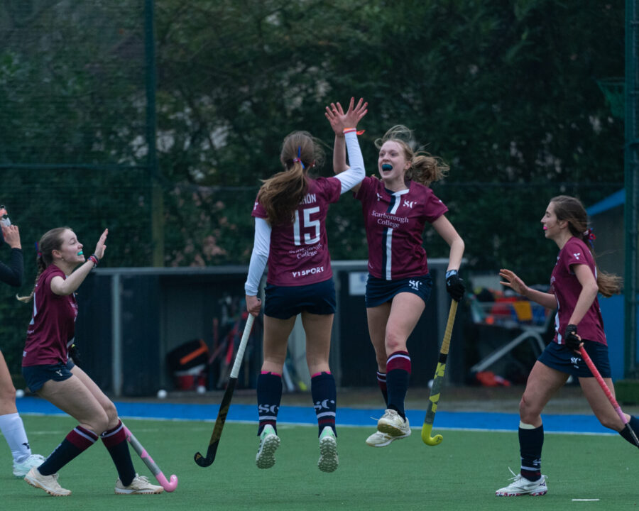 Senior Girls' Hockey team celebrating scoring